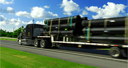 A truck with pipes on the back of it.