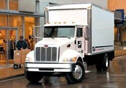 A white truck parked in front of a building.